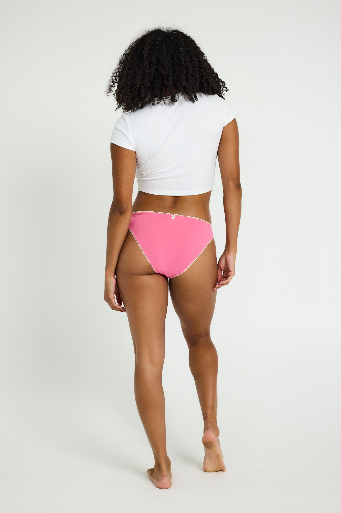 דוגמנית לובשת תחתון לולה צ'יקי בגזרה נמוכה עם פס תחרה, מבט מאחור.