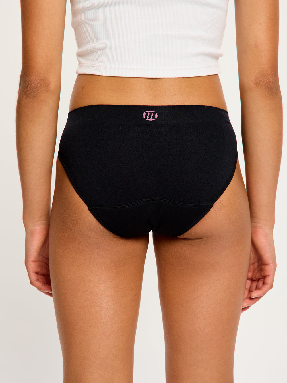 נערה לובשת תחתון סופטסטרצ' ביקיני בצבע שחור, מבט תקריב מאחור, מדגיש את הגזרה ללא תפרים וכיסוי הישבן המלא. מידת הדוגמנית- Youth Small