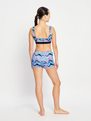 מבט מהגב על טופ בגד ים דו-צדדי לנערות, עיצוב ספורטיבי ונוח לכל פעילות במים. מידת הדוגמנית- 10-12.