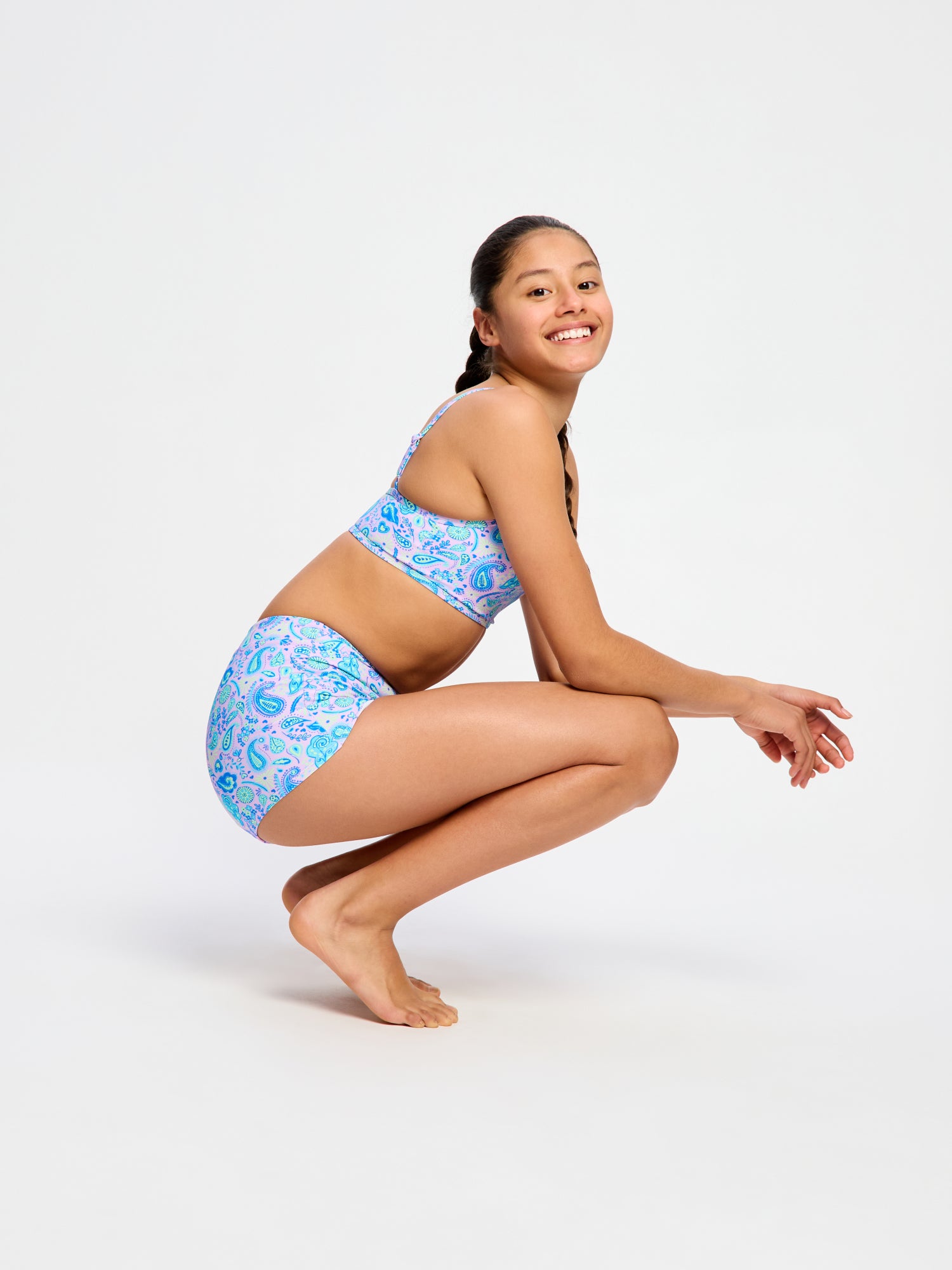 נערה בבגד ים מכנסון של מודיבודי, מבט מהצד בישיבה – הגנה מושלמת לשחייה בטוחה בזמן מחזור. מידת הדוגמנית- 10-12