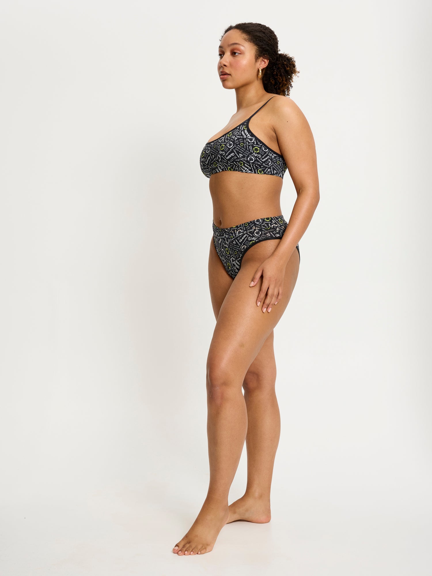 דוגמנית לובשת את הטופ של סמיילי-וורלד, מבט מהצד. מידת הדוגמנית: L