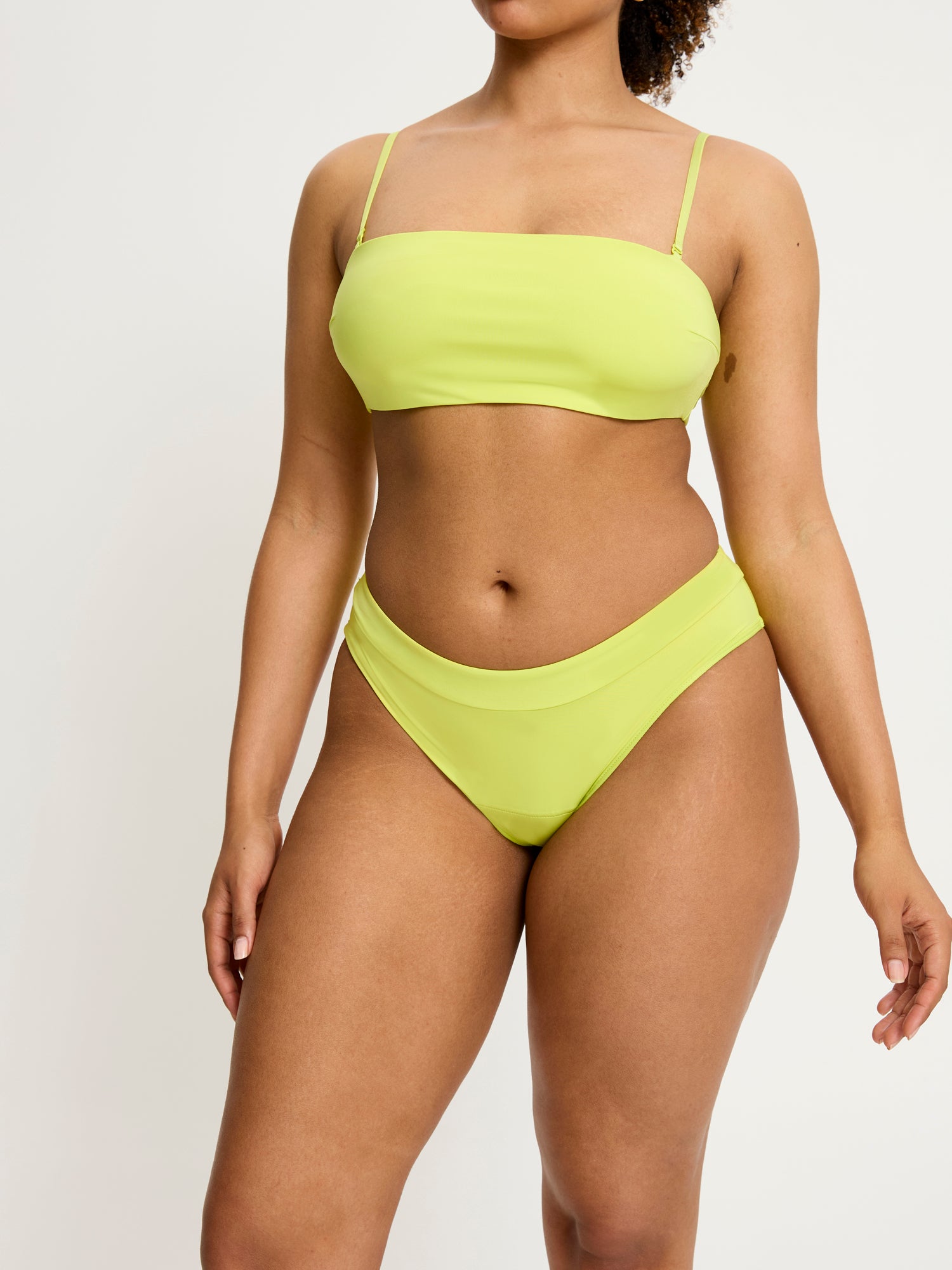 דוגמנית לובשת תחתון צ'יקי בריף מקולקציית סמיילי-וורלד, מבט מהחזית המציג את הגזרה החלקה. מידת הדוגמנית L