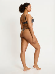 דוגמנית לובשת חוטיני מחזור מקולקציית סמיילי-וורלד, מבט מהצד המציג את הגזרה המינימליסטית. מידת הדוגמנית: L